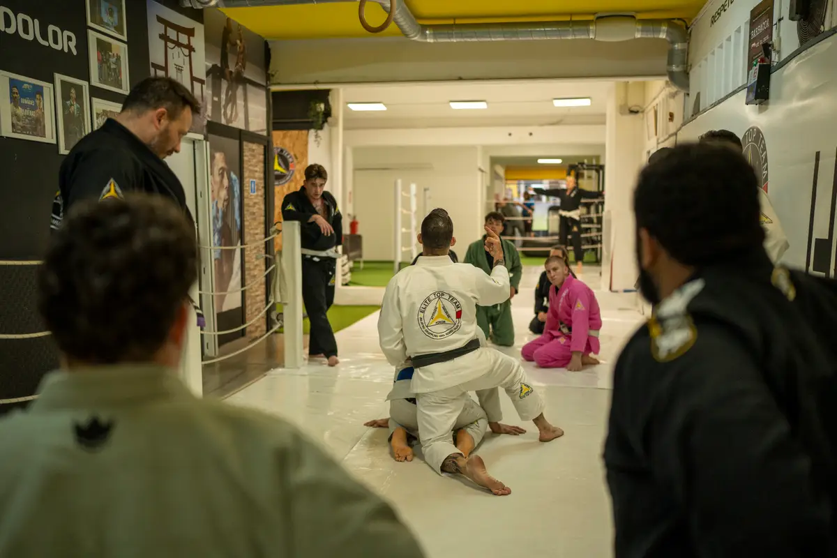 Alumnos en corro viendo al instructor mostrar una técnica